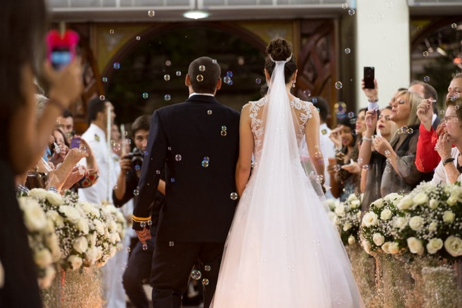 Example image of a couple leaving their wedding ceremony to some bubbles from far away with the Nikon 70-200