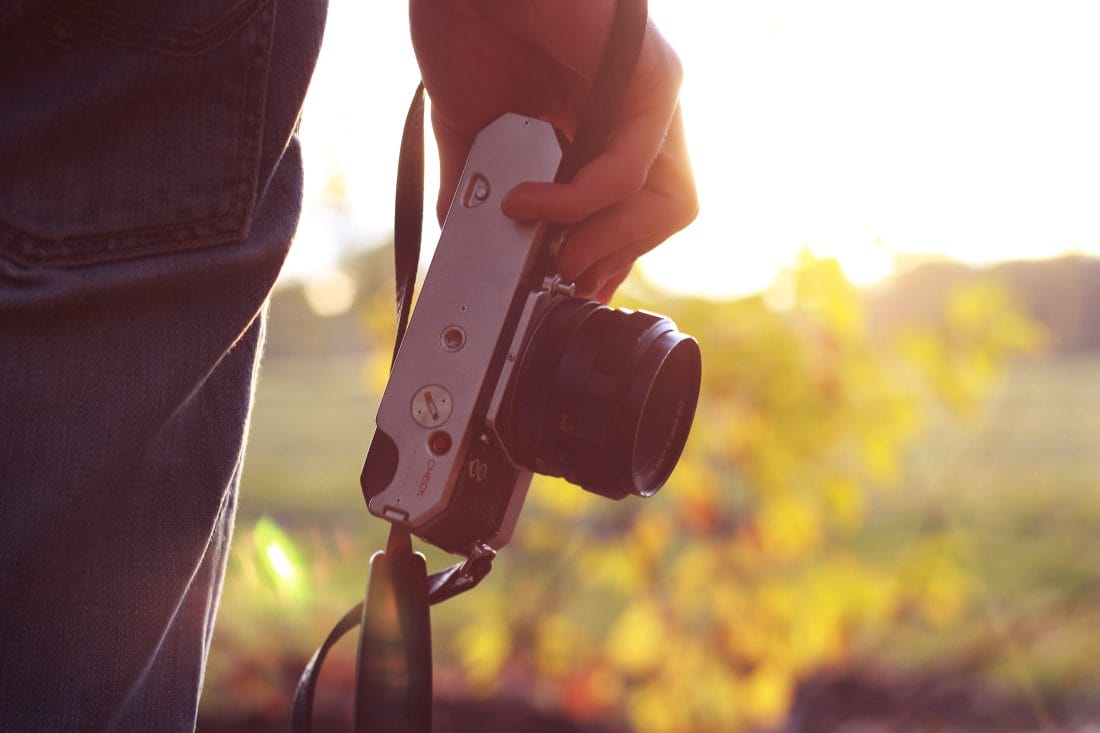 Image of a camera in someone's hand to start out guide on how to take photos