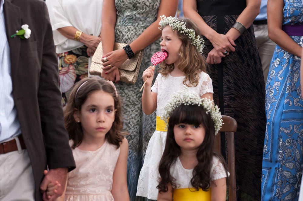 Image of girls at a wedding ceremony, one of which is licking a lollipop