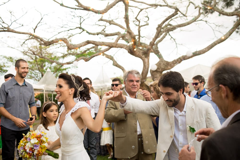 Image of a bride and groom holding hands as they leaving their outdoor wedding ceremony