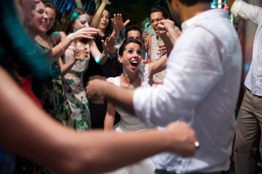 Image of bride and groom during exciting part of song dancing with each other and laughing