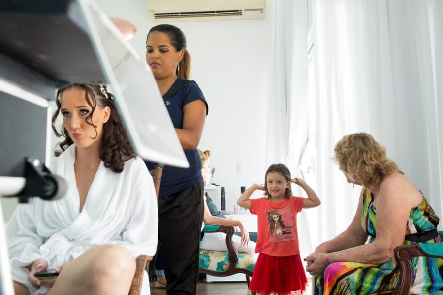 Image showing a bride getting her hair done while her niece plays in the background with another relative