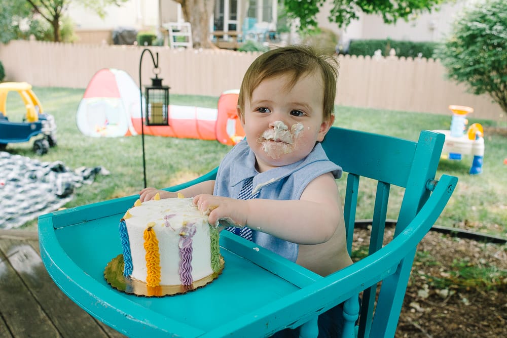 image of a one year old eating birthday cake for the first time as an example about one year old birthday photography