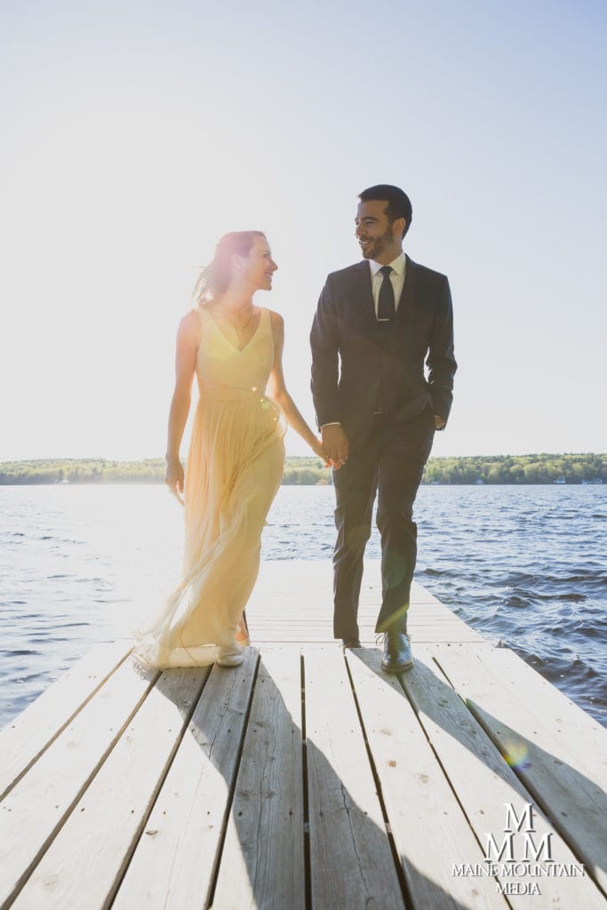 photo of a couple on a lake dock looking each other in the eyes and backlit by the sun by photographer Paul Friedman