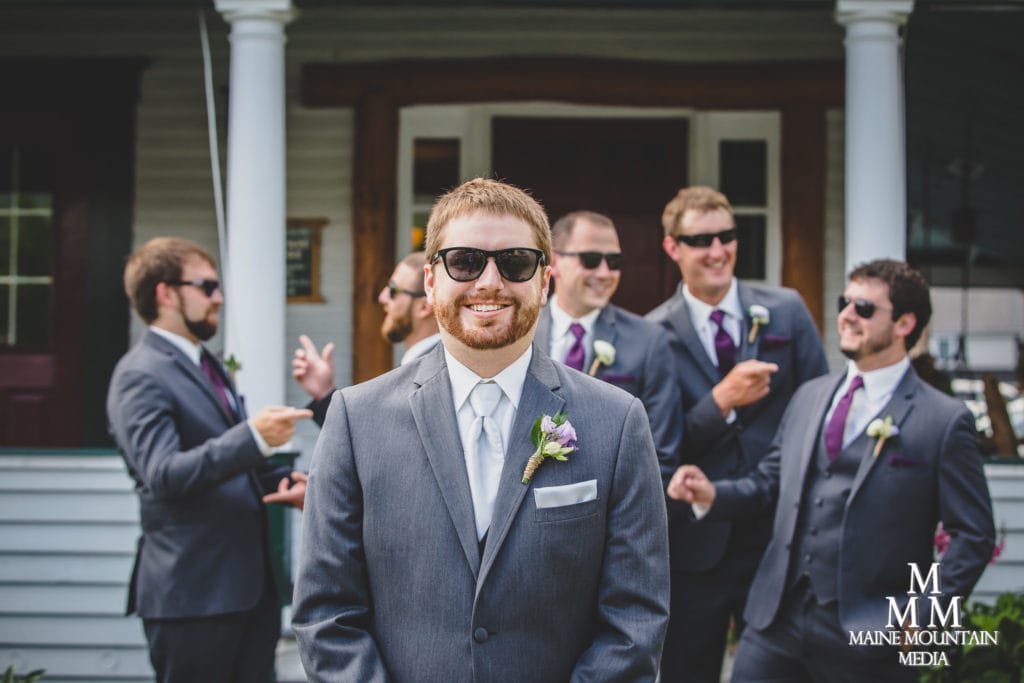 Wedding photography image by Paul Friedman showing a groom wearing his suit and sunglasses with his groomsmen behind him