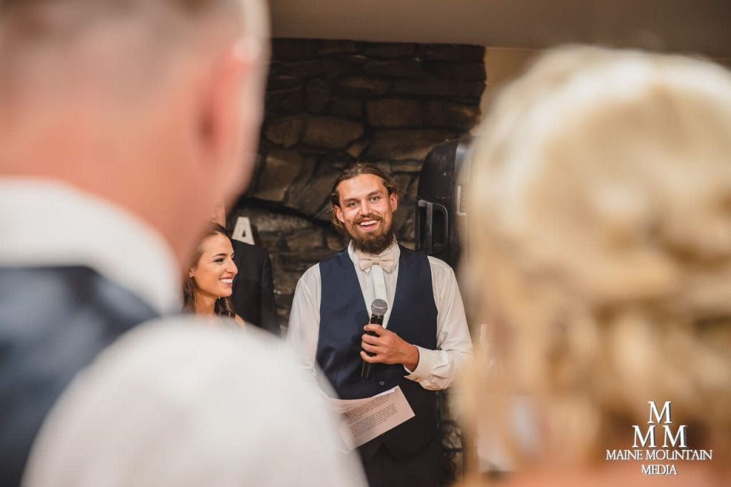 Photo of best man giving a speech from the angle of the bride and groom