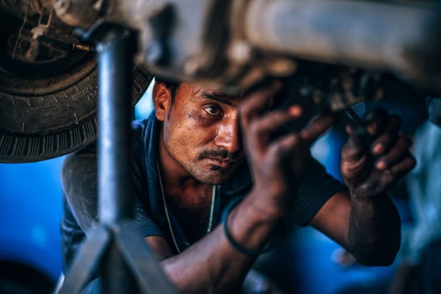 Creative candid portrait of a man working on a car
