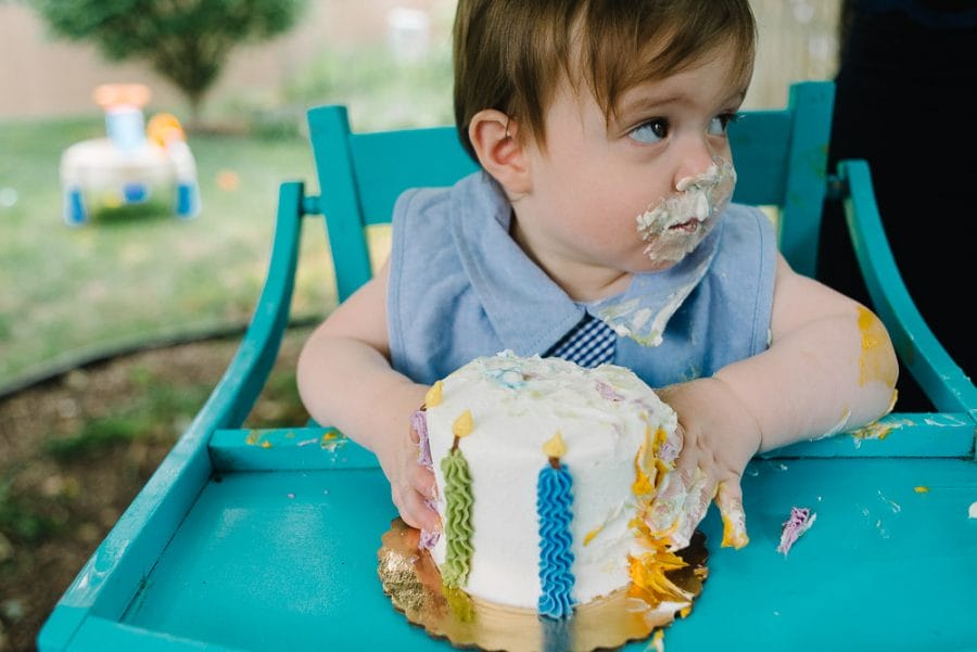 Image of a one year old eating cake on his first birthday shot on a 35mm lens