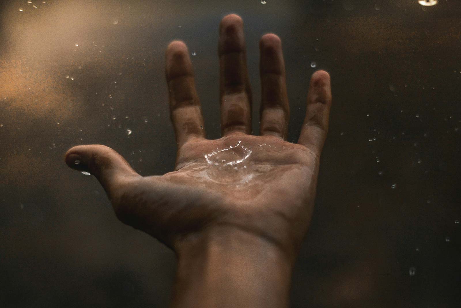 Rain photography image of a person holding their hand out in the rain