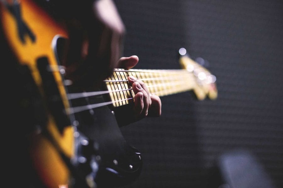 Up close image of someone playing an electric bass guitar