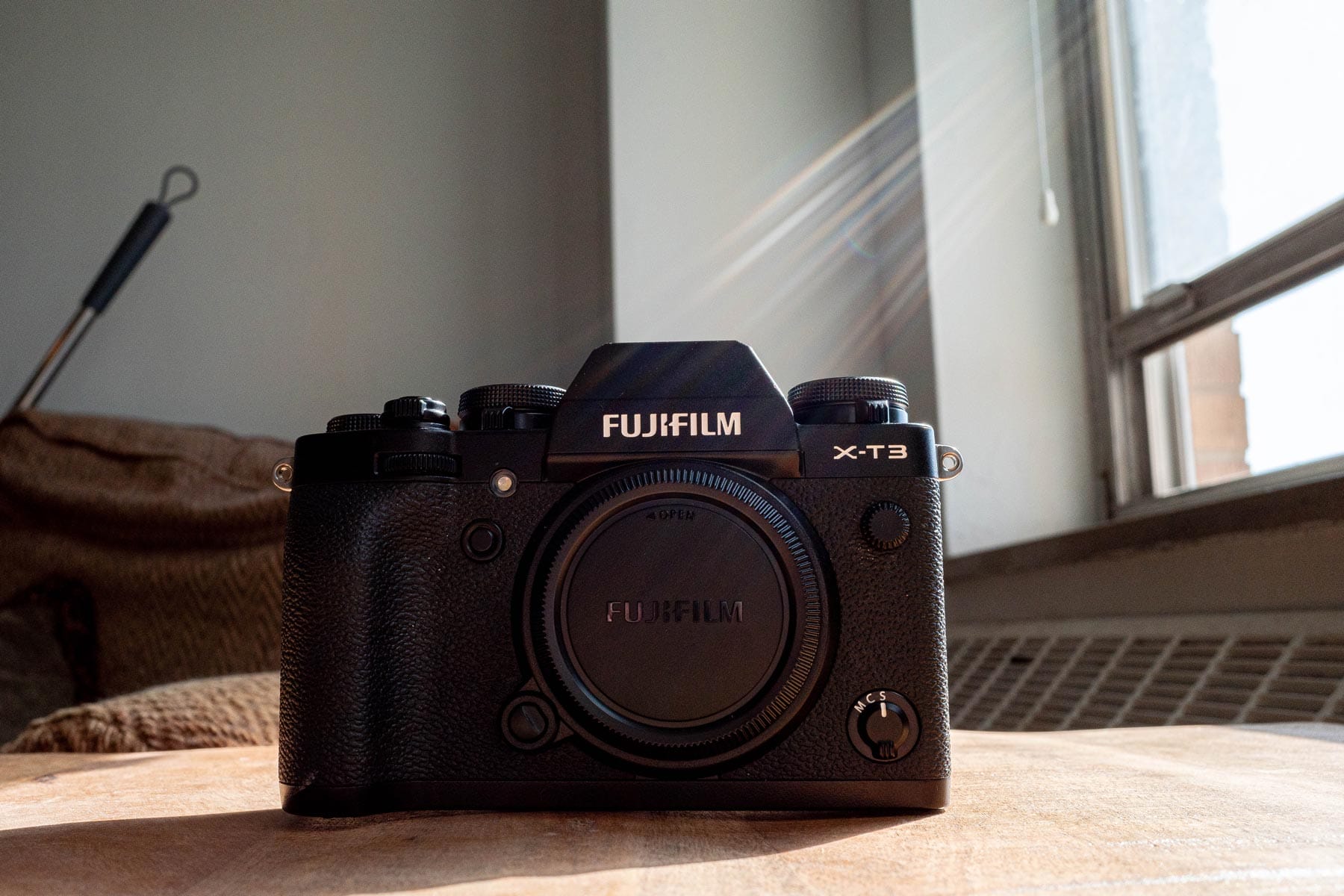 Image of the Fujifilm X-T3 on a wood table next to a window
