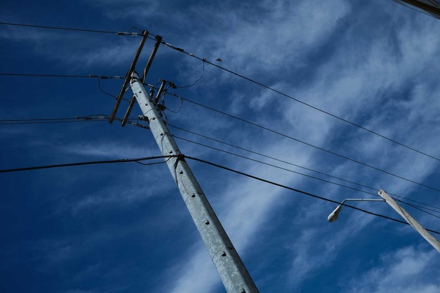 Image of power lines and blue sky/white clouds