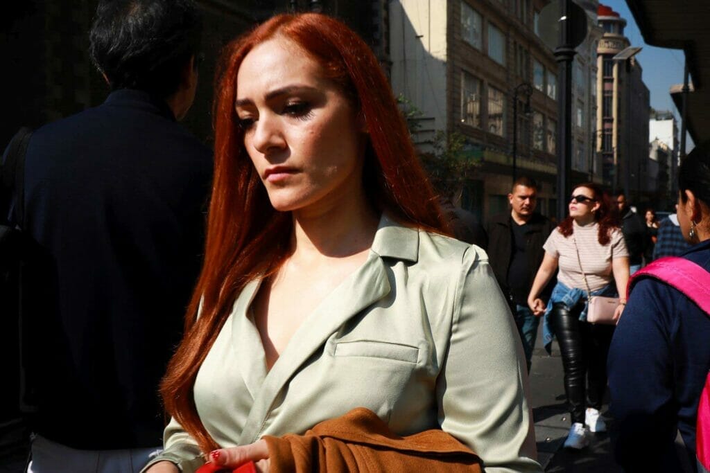A woman with red hair dressed professionally.