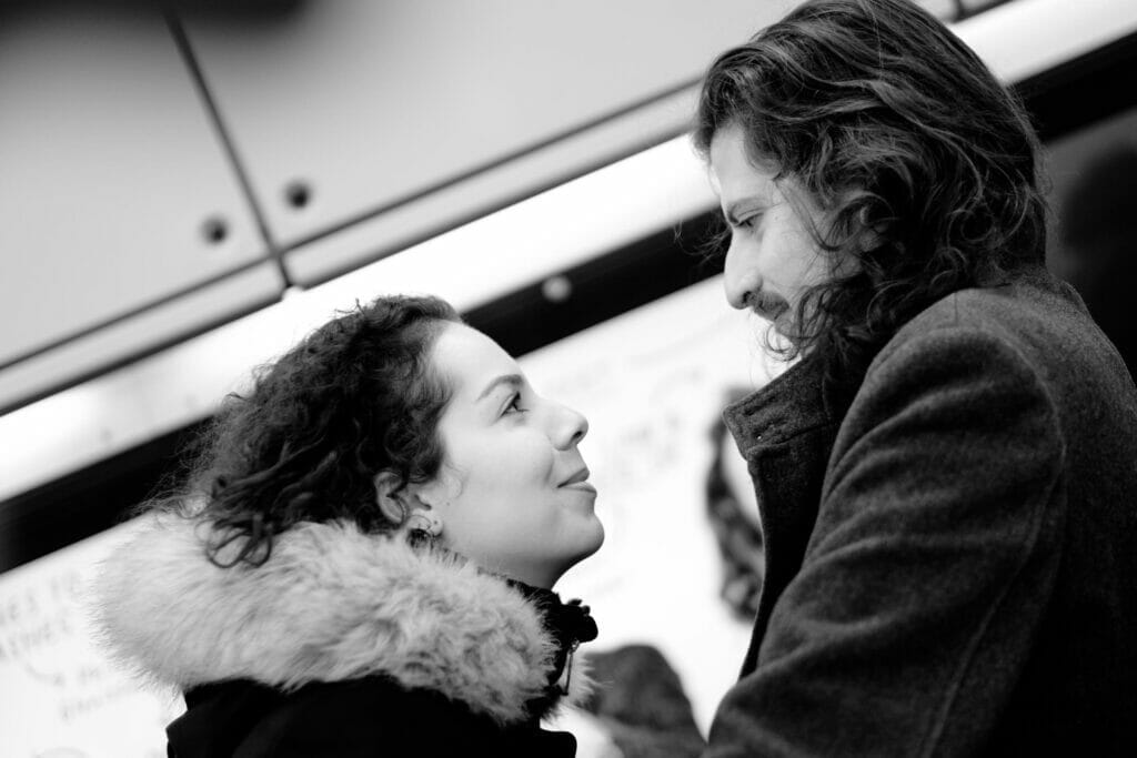 A man and woman smiling at each other on public transportation.