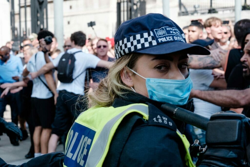 A woman police officer among a crowd.