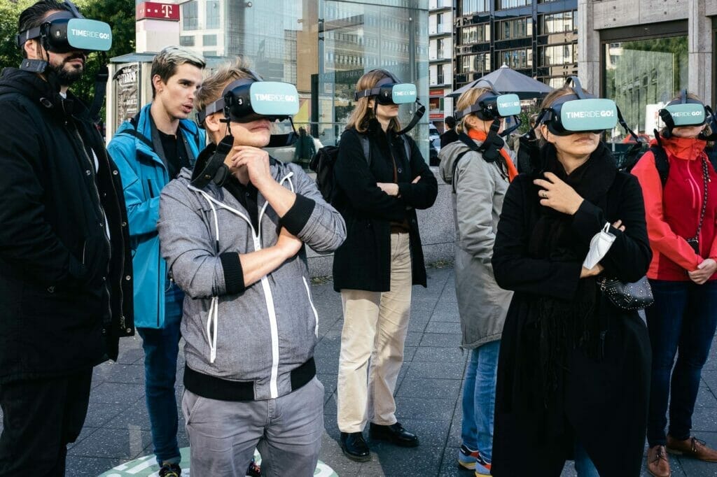 People in a public outdoor space wearing virtual reality headsets.
